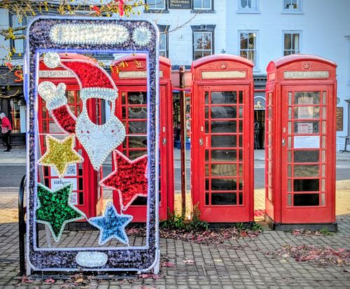 Free Colorful Christmas lights and red phone booths in Ripon, UK create a festive scene. Stock Photo