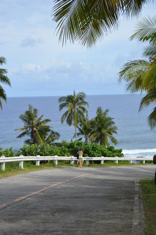 Free A serene road lined with palm trees leading to a tropical ocean view, perfect for travel destinations. Stock Photo