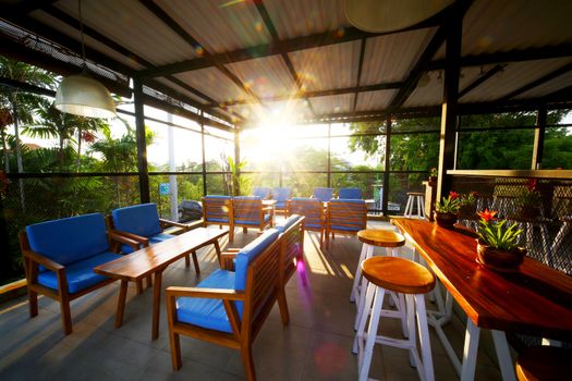 Inviting open-air patio in Bali with tropical greenery and vibrant seating.