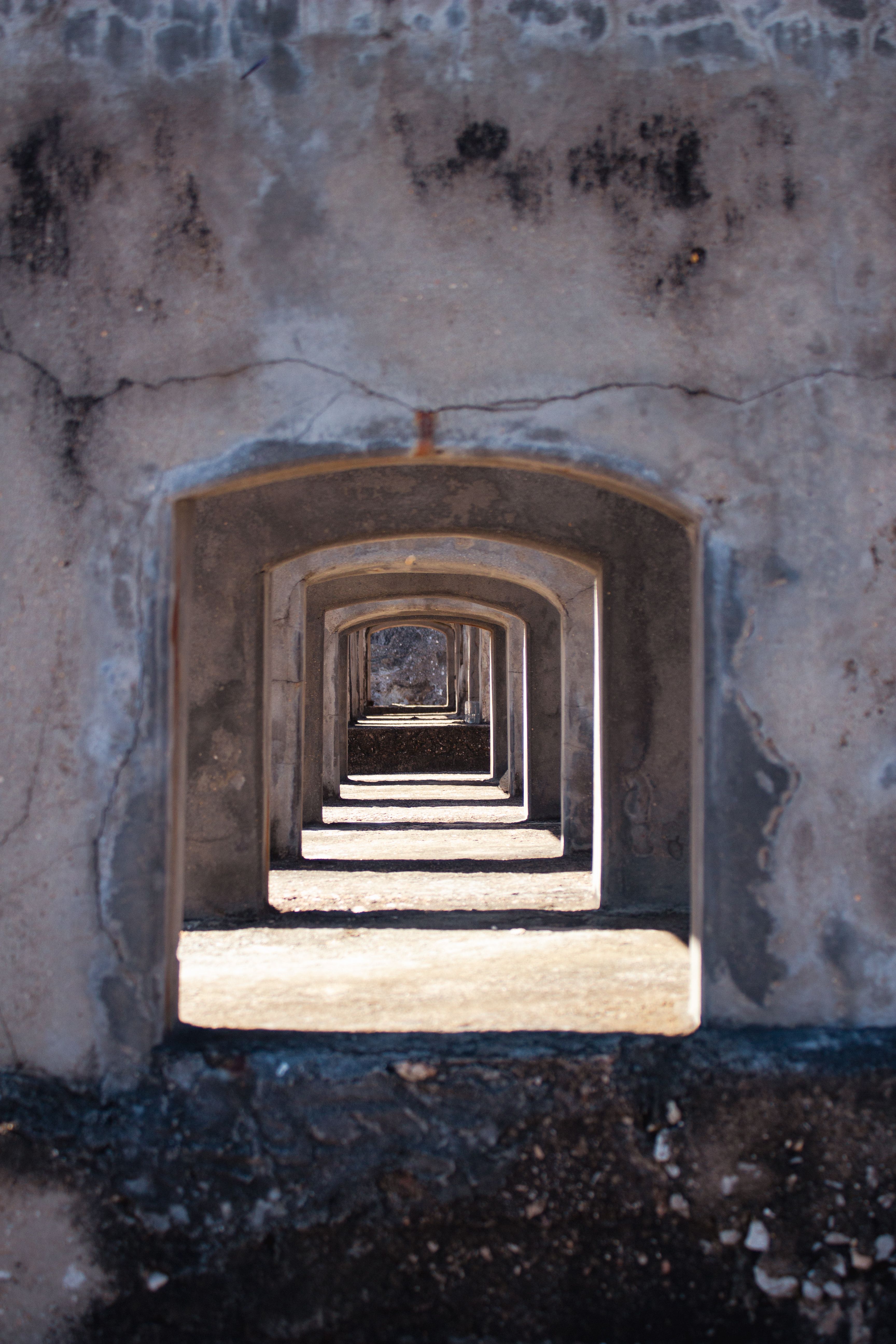 Gratuit Une série d'arcades formant un tunnel, mettant l'accent sur la profondeur visuelle et la perspective dans une structure en béton. Photos