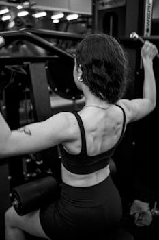 A woman engaged in weight training on a gym machine, showcasing fitness and strength.
