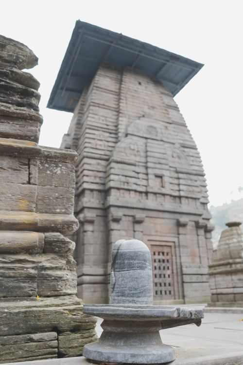 Free Explore the intricate design of an ancient temple showcasing a central lingam statue outdoors. Stock Photo