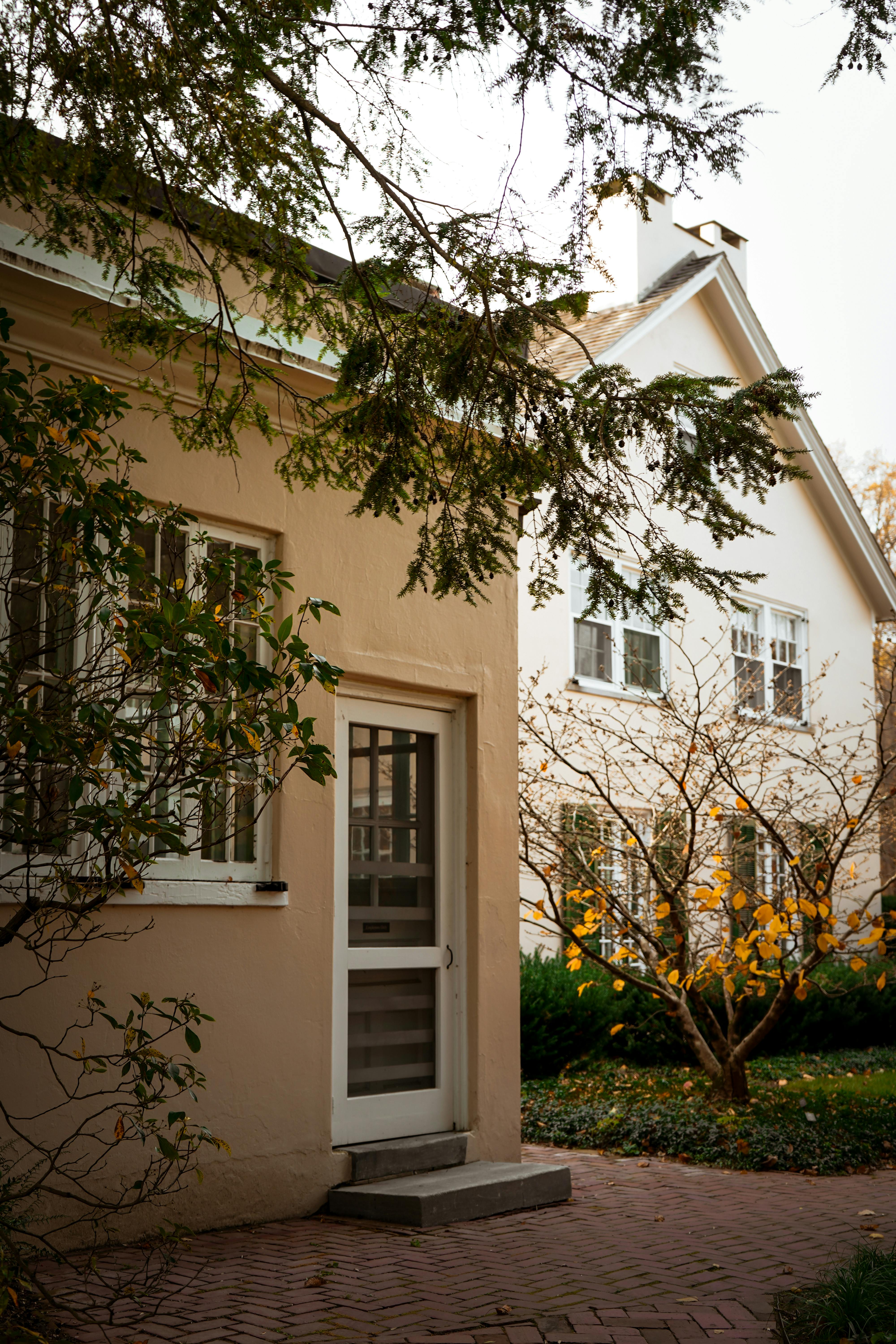 A warm, inviting suburban home surrounded by fall foliage and a peaceful garden.