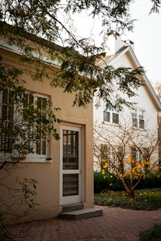 A warm, inviting suburban home surrounded by fall foliage and a peaceful garden.
