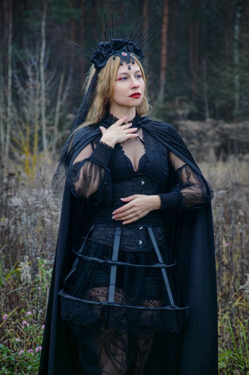 Free Gothic woman in dark, enchanting attire posing in a mysterious forest setting. Stock Photo