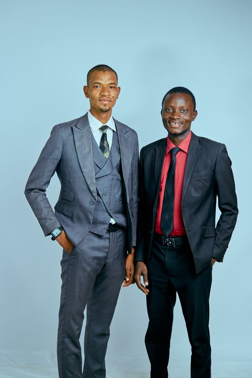 Free Two confident businessmen posing in formal attire against a neutral background. Stock Photo