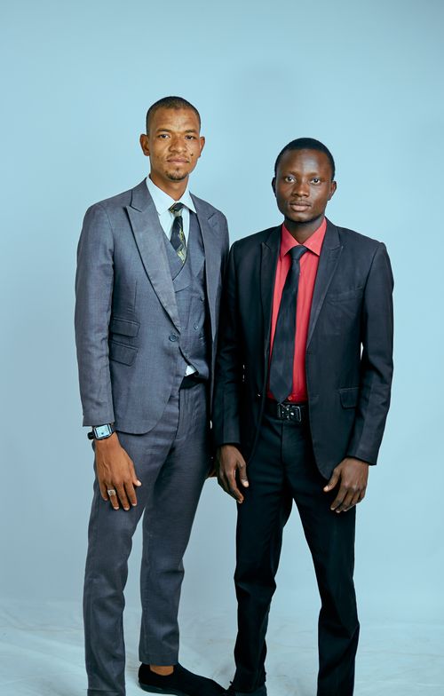 Free Two well-dressed professionals in suits posing for a formal portrait against a plain background. Stock Photo
