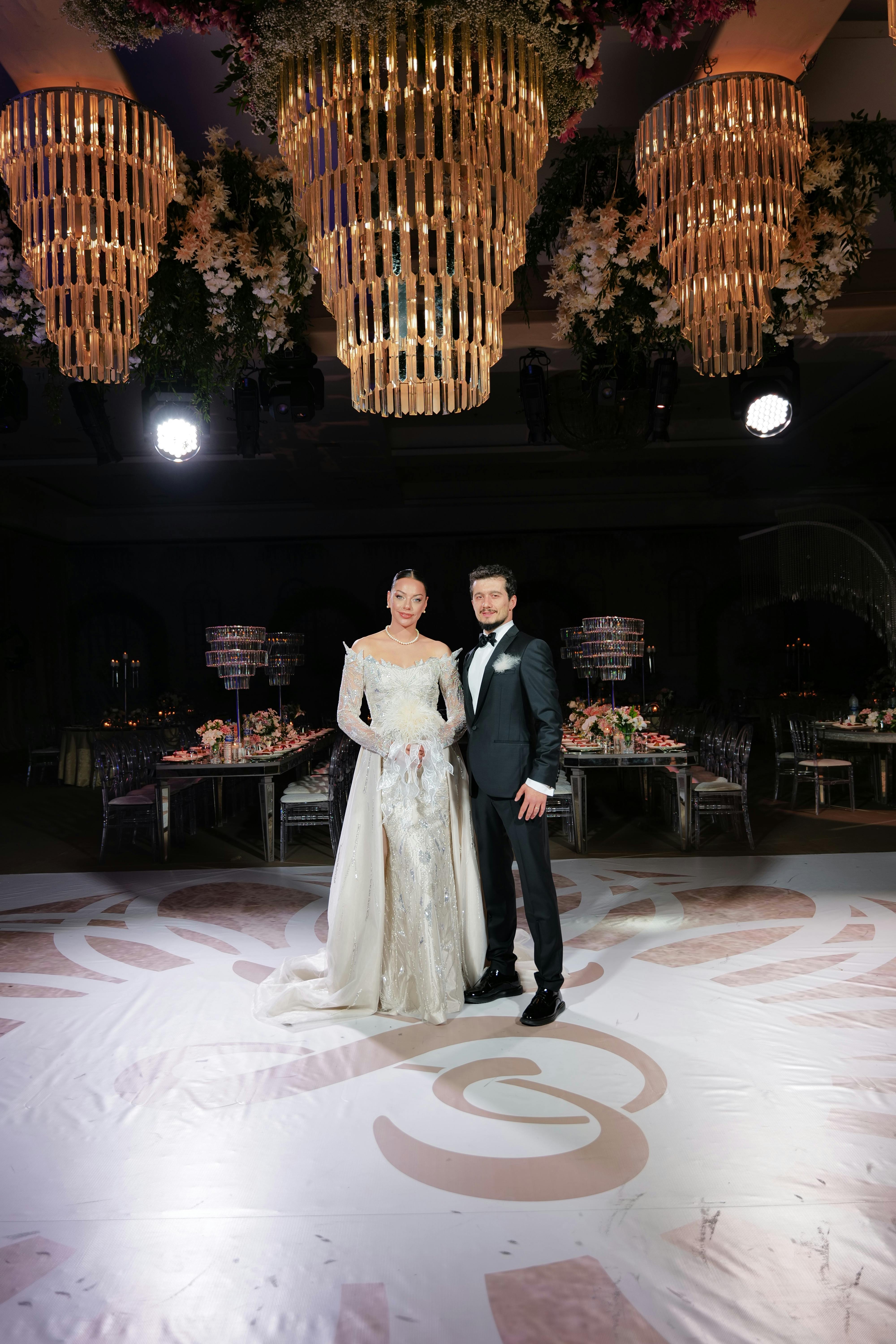 Wedding couple posing under chandeliers in a luxurious venue in Denizli, Türkiye.