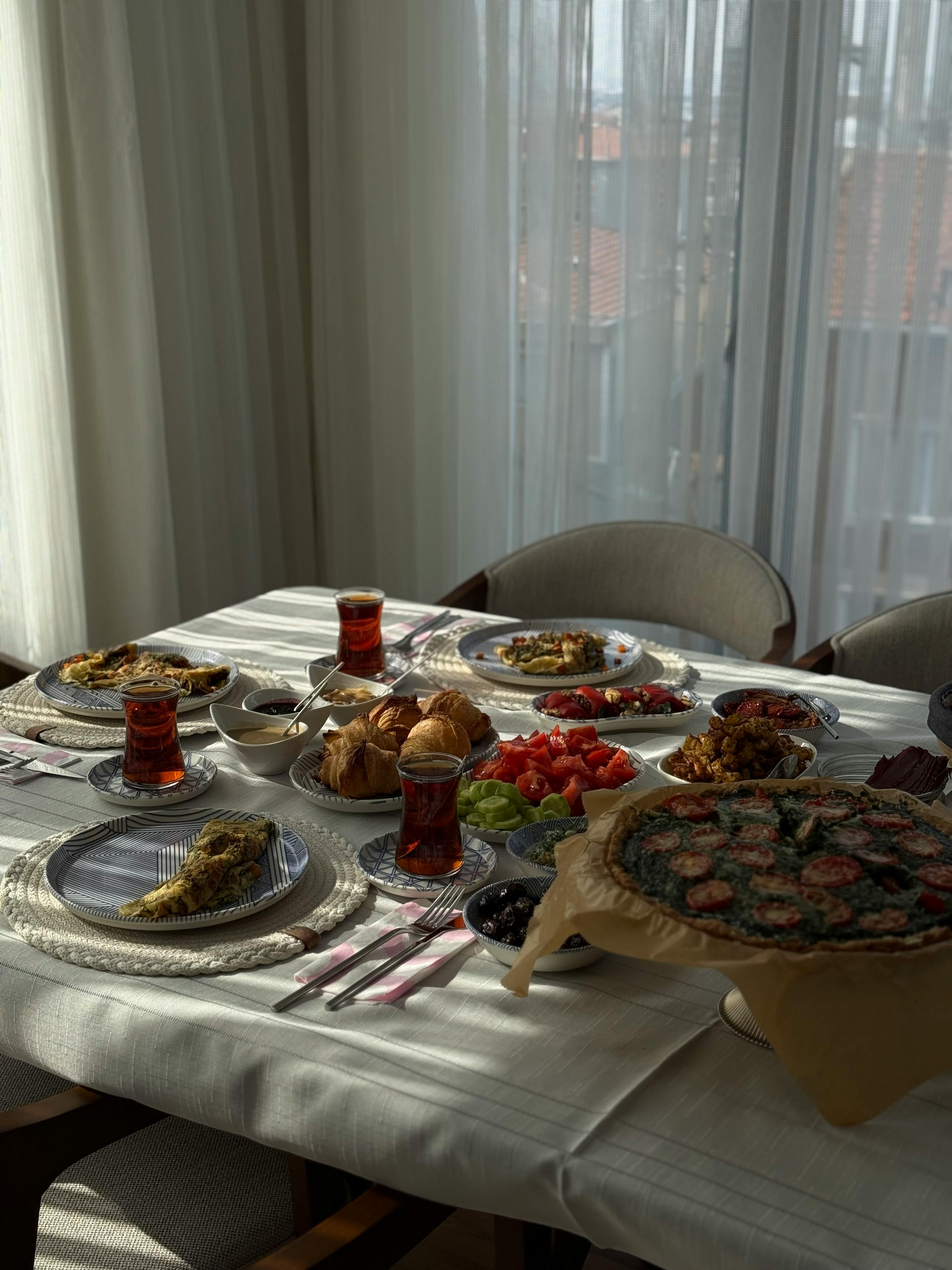A vibrant Turkish breakfast spread featuring tea, pastries, and more in a cozy İstanbul setting.