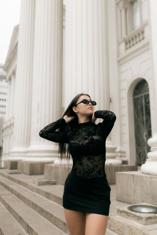 Free Fashionable woman in black dress and sunglasses near classical architecture. Stock Photo