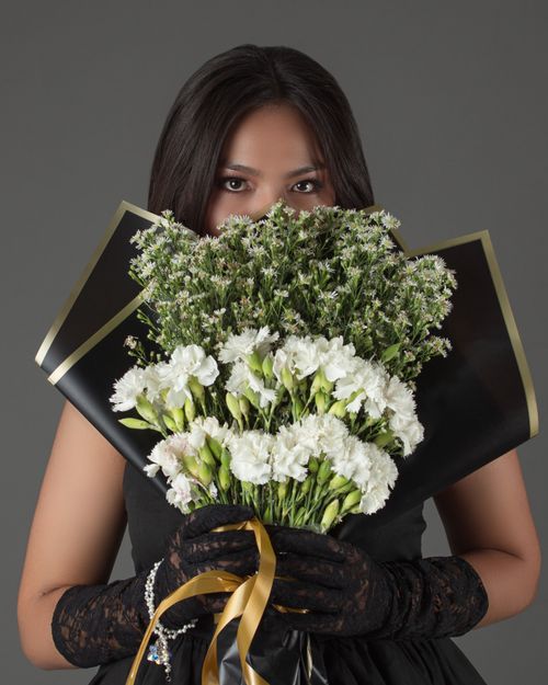 Free Woman in black dress with a bouquet of white and green flowers in Cochabamba, Bolivia. Stock Photo