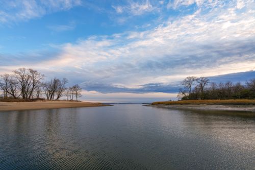 Free Peaceful river scene with dramatic clouds and soft lighting, perfect for nature themes. Stock Photo