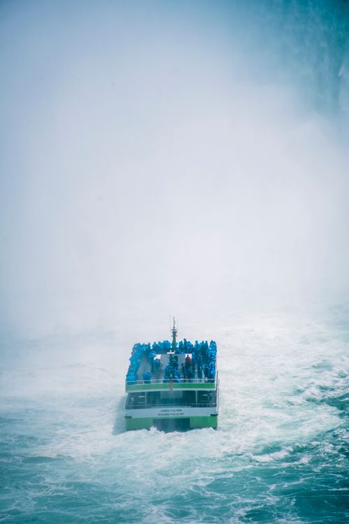 Free A tour boat filled with people in blue ponchos approaches the mist of Niagara Falls. Stock Photo