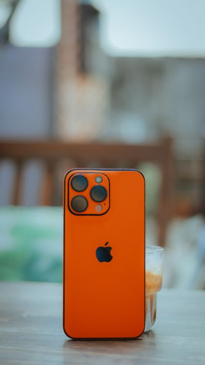 Bright Orange Smartphone on Outdoor Table · Free Stock Photo