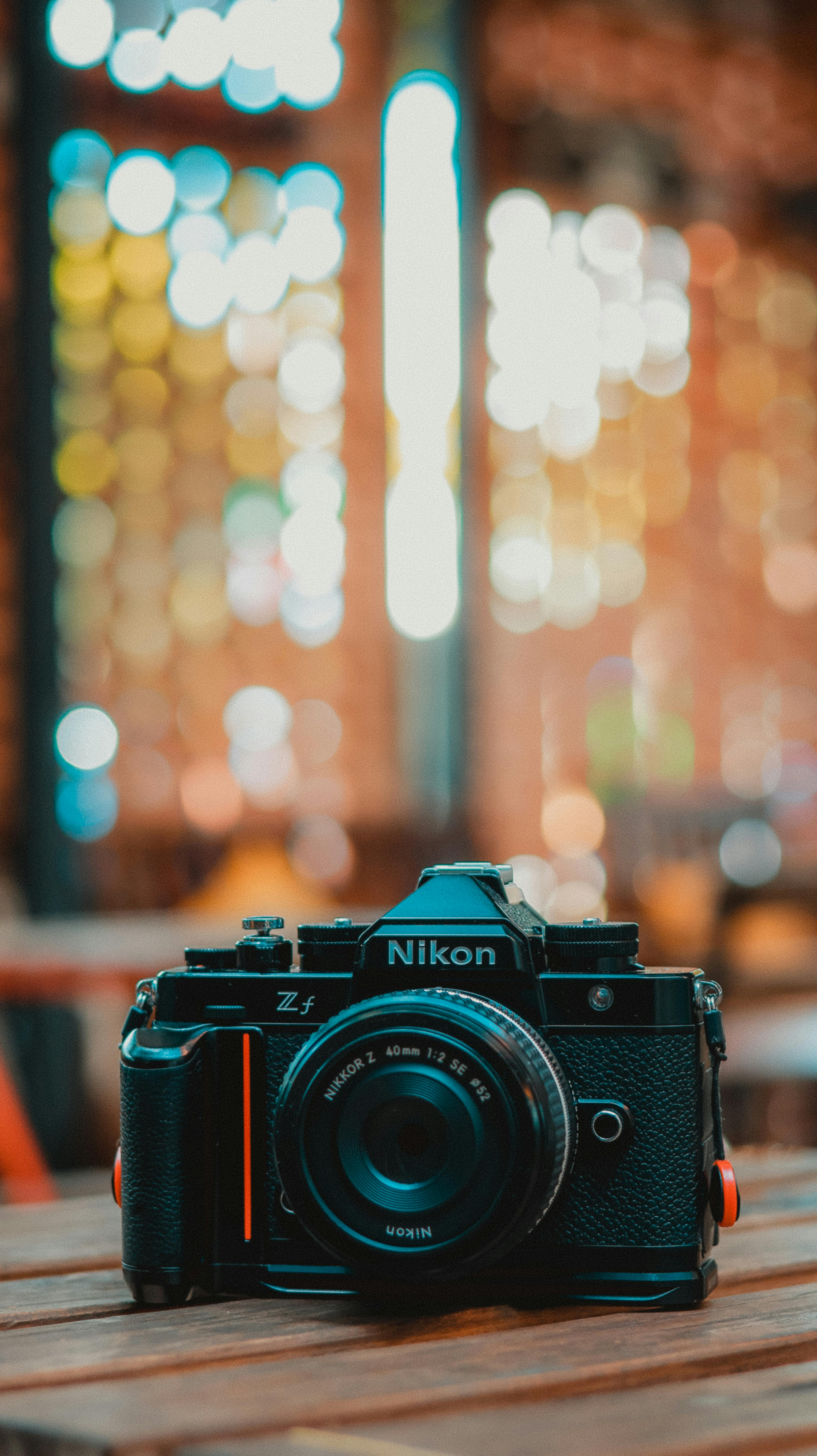 Vintage Nikon Z camera on a wooden table with a blurred bokeh background indoors.