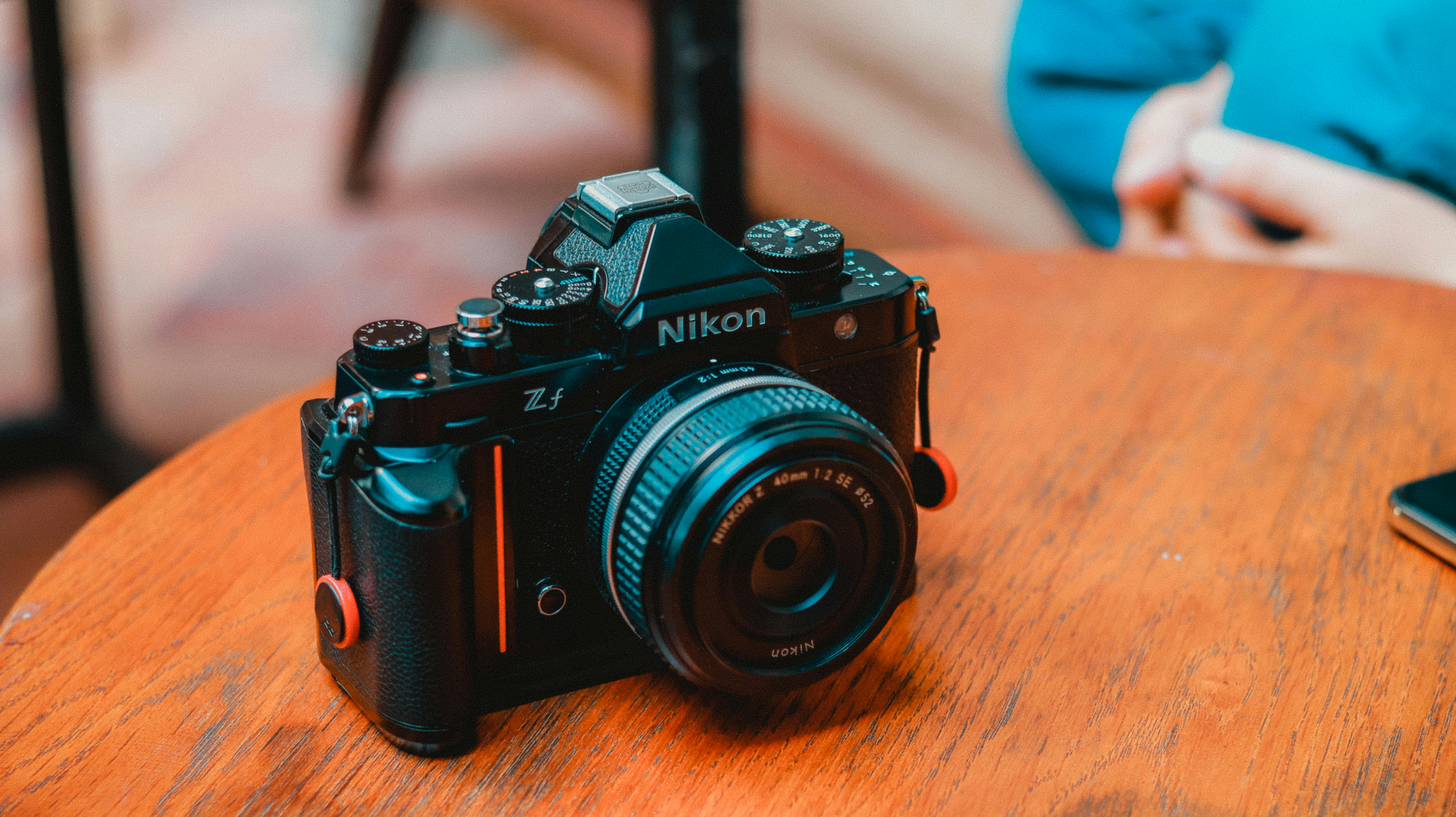 Close-up of a Nikon F100 Camera Standing on a Wooden Table · Free