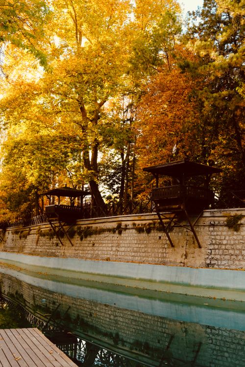 Free Serene autumn scene with vibrant trees and canal reflections in the afternoon light. Stock Photo