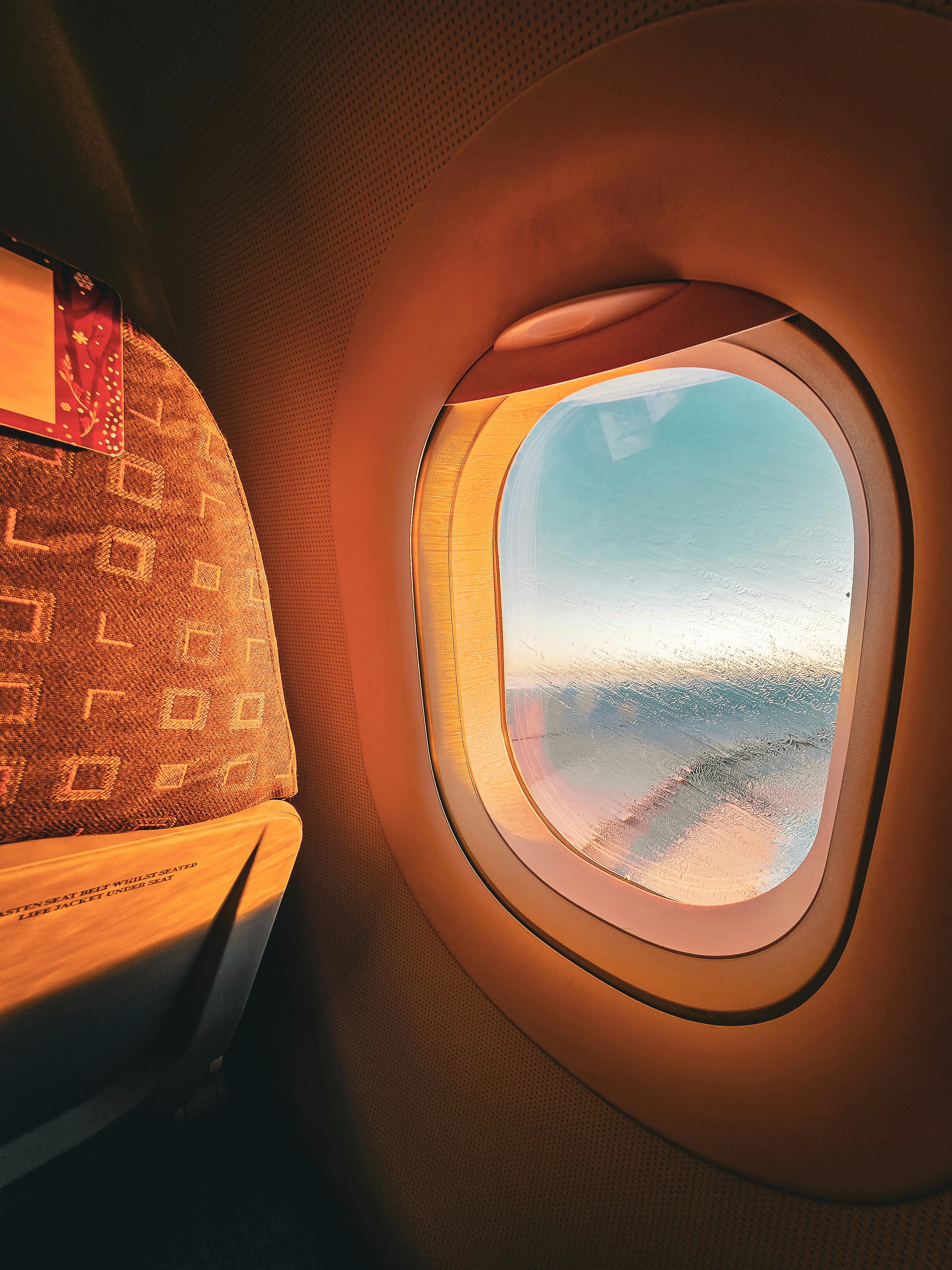 Sunlit Airplane Window View During Flight · Free Stock Photo