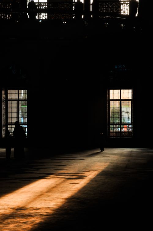 Free Warm sunlight casting dramatic shadows in a grand architectural interior with tall windows. Stock Photo