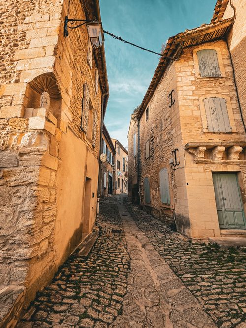 Free Explore a quaint, rustic cobblestone street with classic stone buildings in the heart of Provence, France. Stock Photo