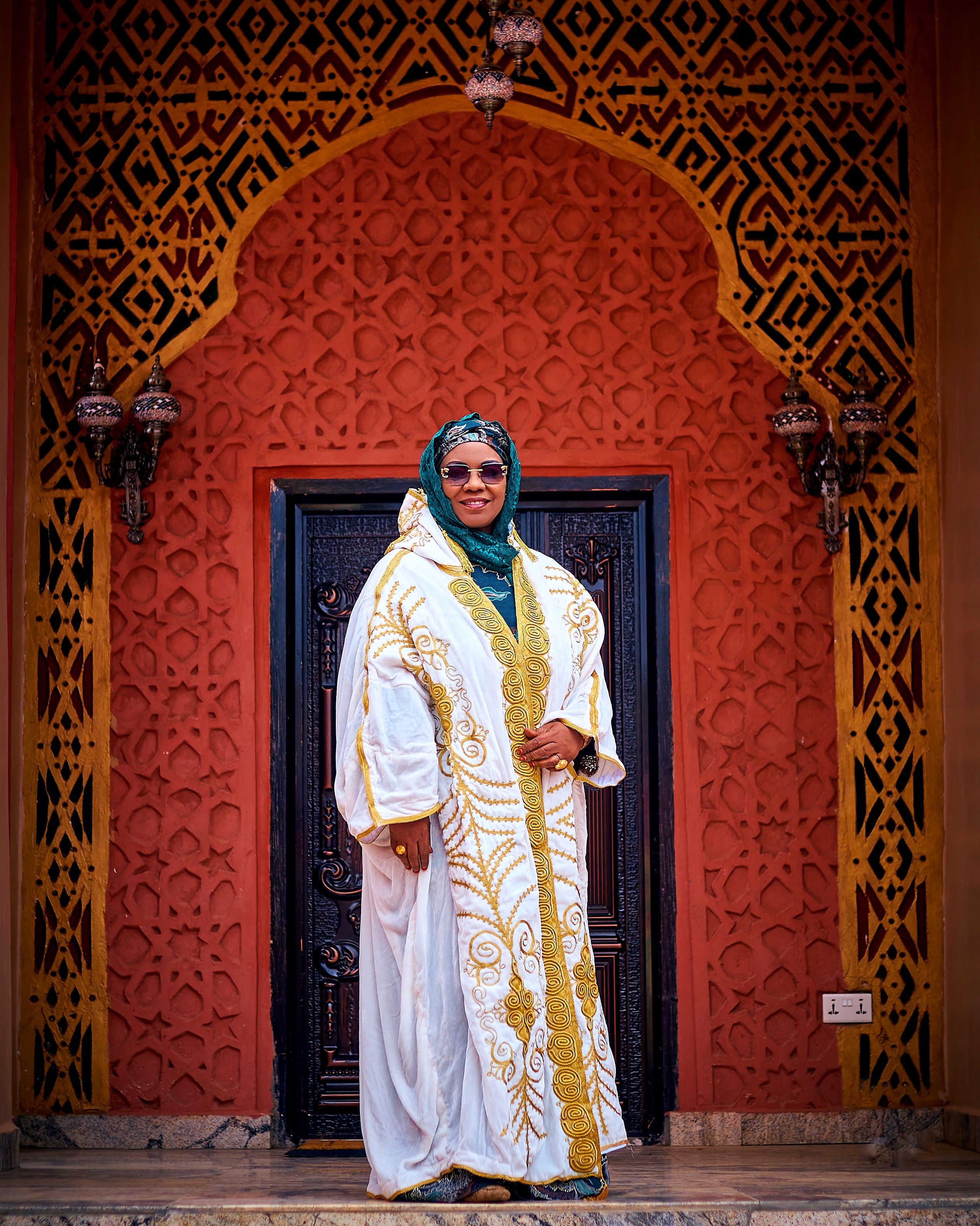 Elegant Woman in Traditional Dress at Ornate Doorway · Free Stock Photo
