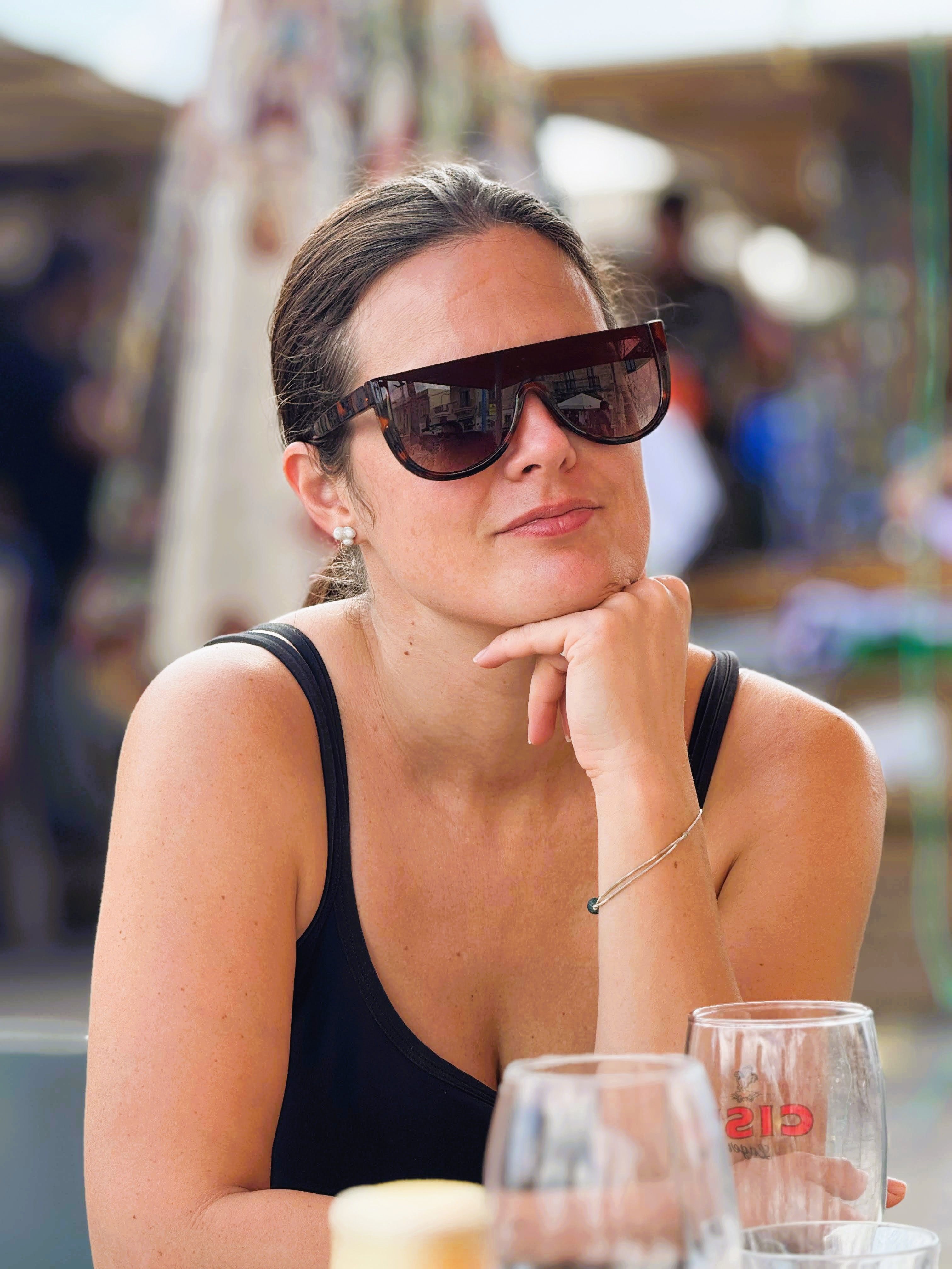 Fashionable woman wearing sunglasses relaxing in an outdoor summer setting.