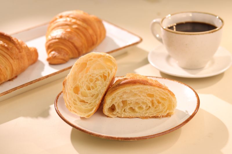 Freshly baked croissants served with a cup of black coffee, perfect for breakfast.