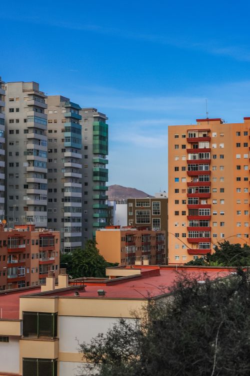 Free Urban cityscape featuring high-rise buildings under a clear blue sky. Stock Photo