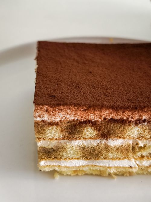 Free Close-up of a tiramisu slice, showcasing delicate layered texture and cocoa topping. Stock Photo