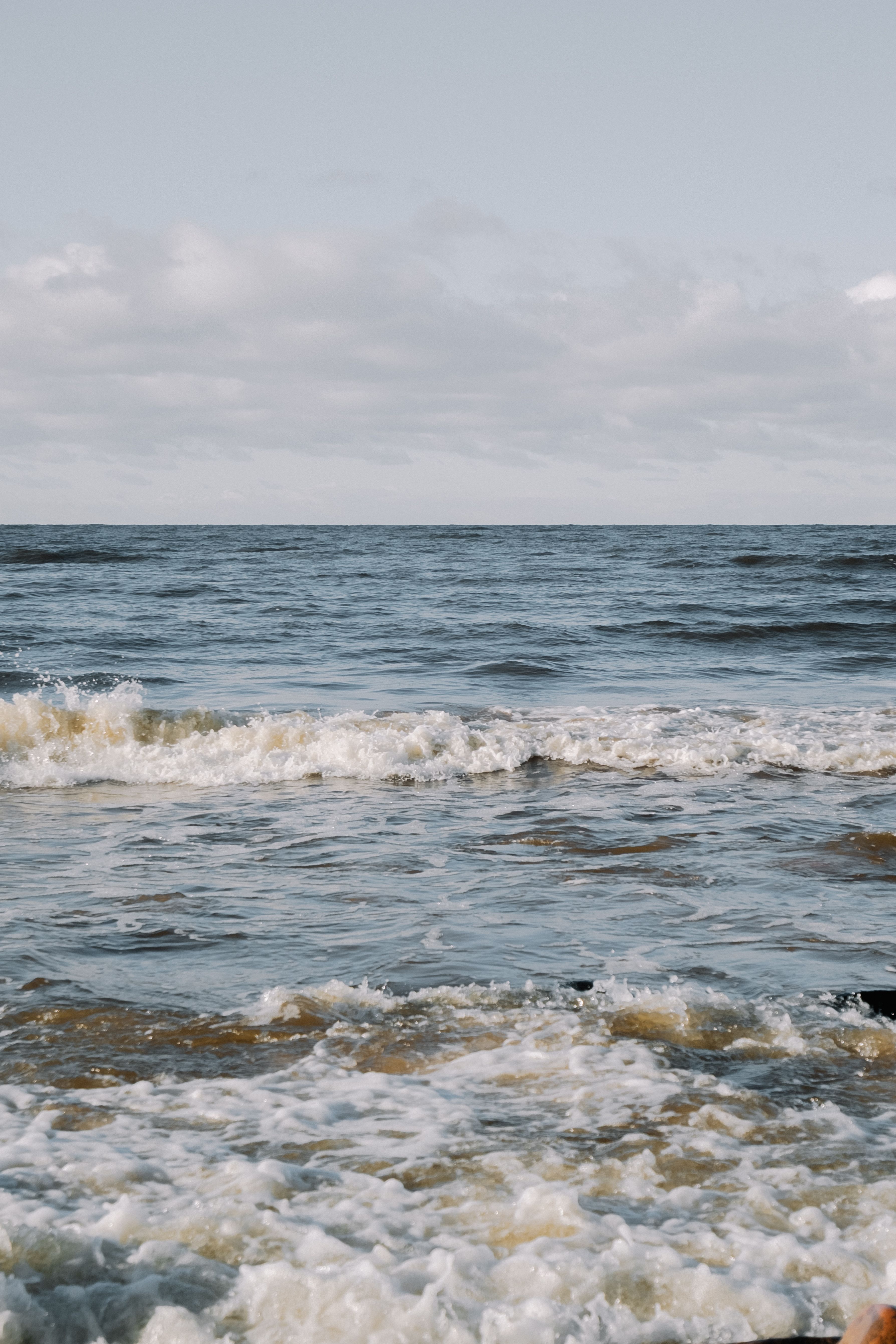Serene Ocean Waves Under Cloudy Sky · Free Stock Photo