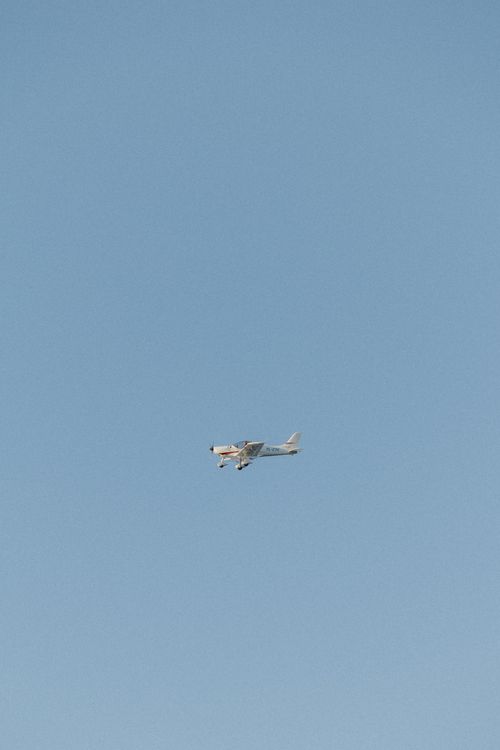 Free A small airplane soars high in a clear daytime sky, showcasing freedom and travel. Stock Photo
