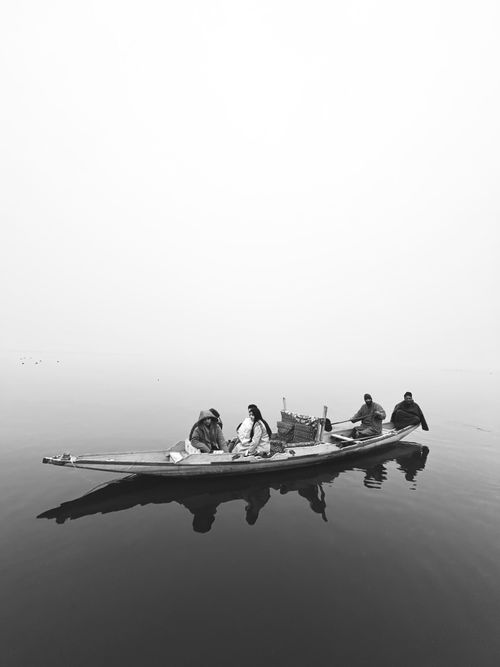 Free Monochrome image of a shikara boat with people on Dal Lake, Srinagar in the mist. Stock Photo