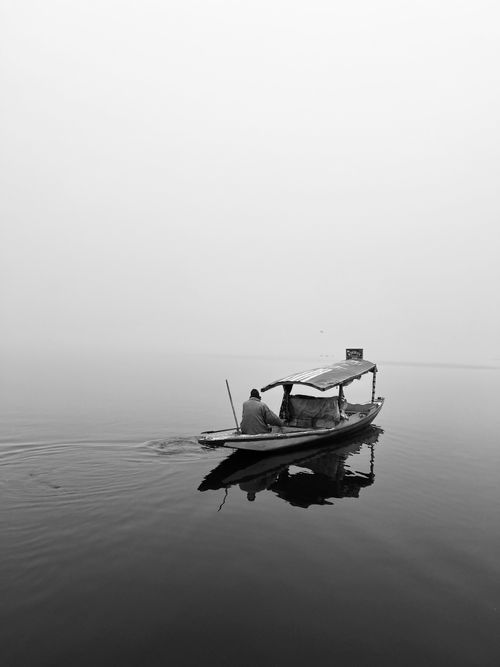 Free Black and white photo of a shikara boat on Dal Lake in Srinagar. Stock Photo