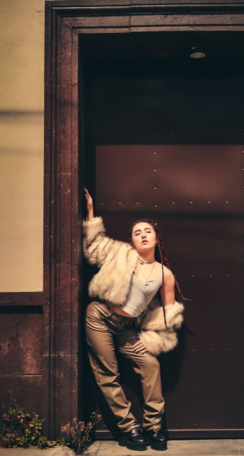 Free Stylish young woman posing with confidence in an urban environment. Stock Photo