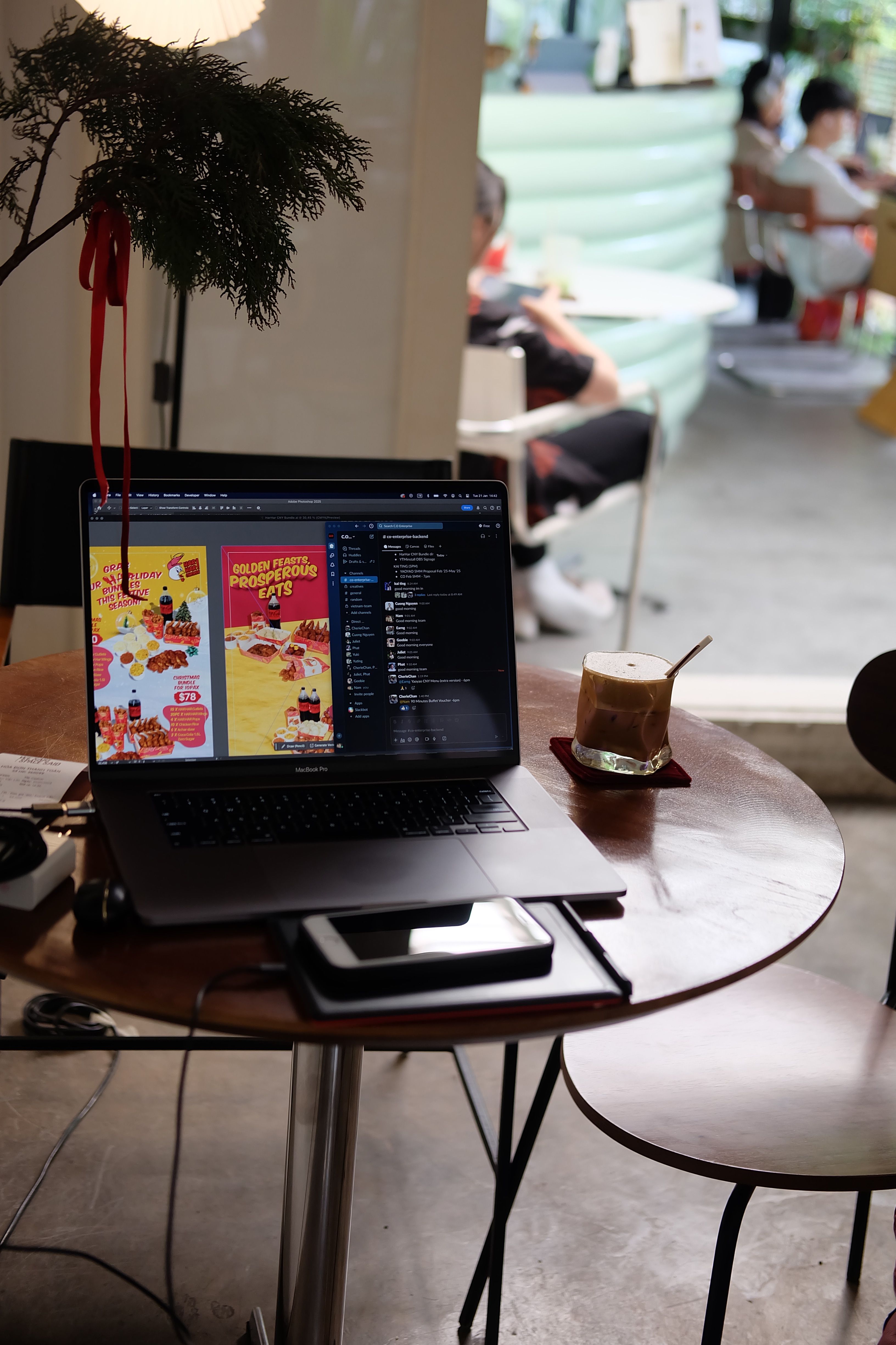 A laptop on a cafe table with a refreshing drink, perfect for remote work in a cozy atmosphere.