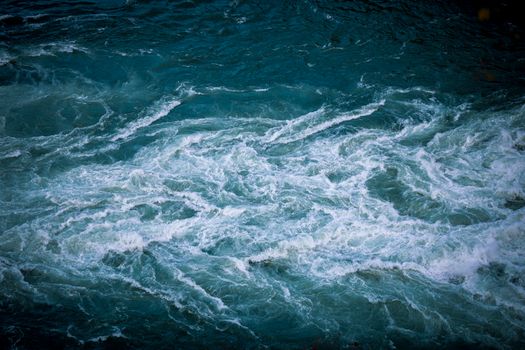 Dynamic whirlpool in vivid turquoise water creating a dramatic natural scene.