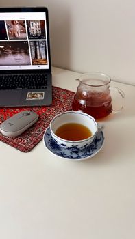 A serene home office setup with tea, laptop, and elegant decor, perfect for productivity.
