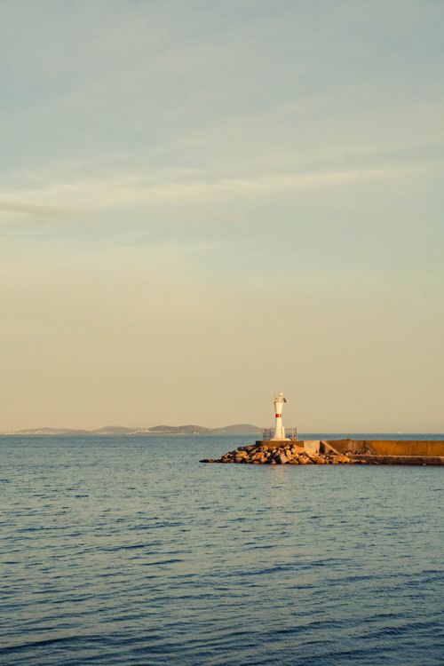 Free A serene coastal scene featuring a lone lighthouse against a calm sea, captured at dusk in Istanbul, Turkey. Stock Photo