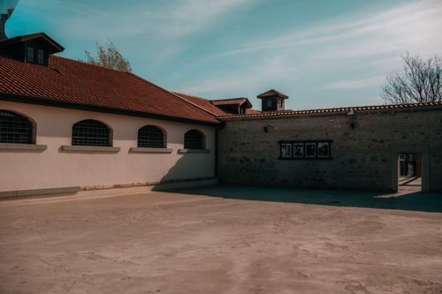 Free Exterior view of a historic building with red tiled roof in an empty courtyard setting. Stock Photo