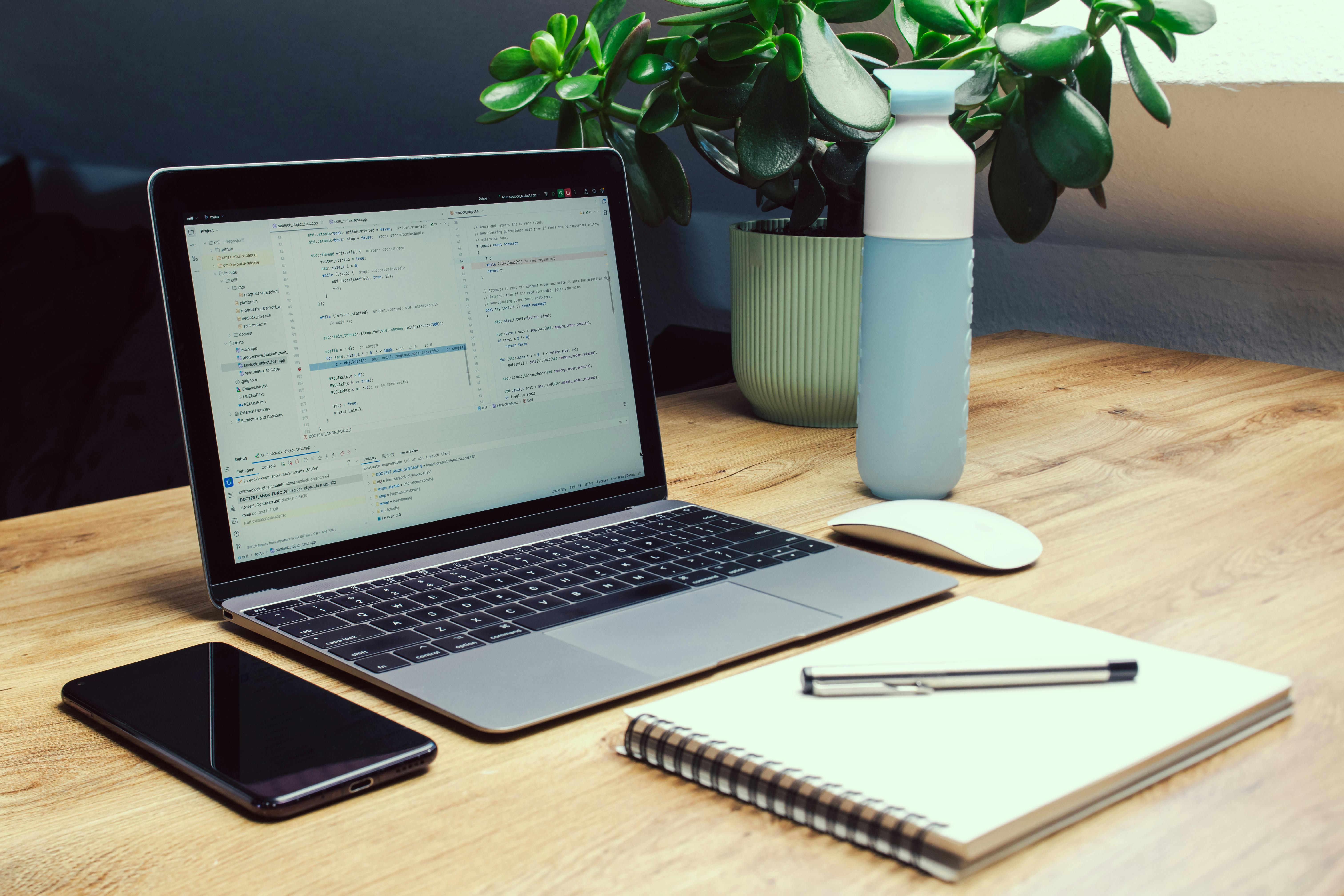 Sleek workspace featuring a laptop, smartphone, and eco-friendly bottle.