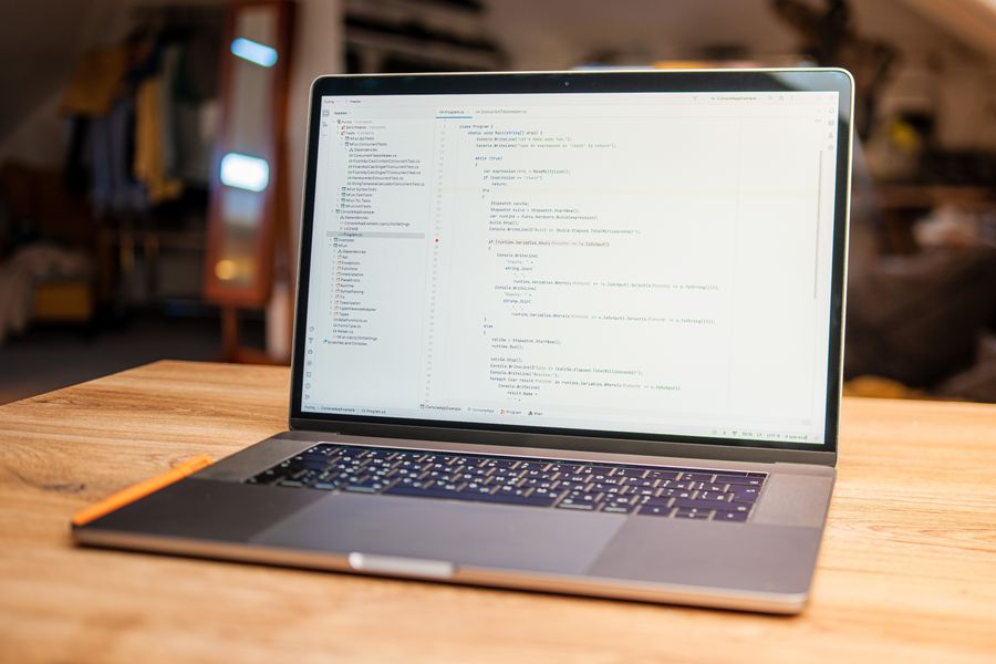 Laptop on a wooden desk showing a code editor — photo by Daniil Komov on Pexels