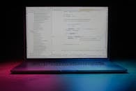 Laptop Displaying Code with Colorful Lighting