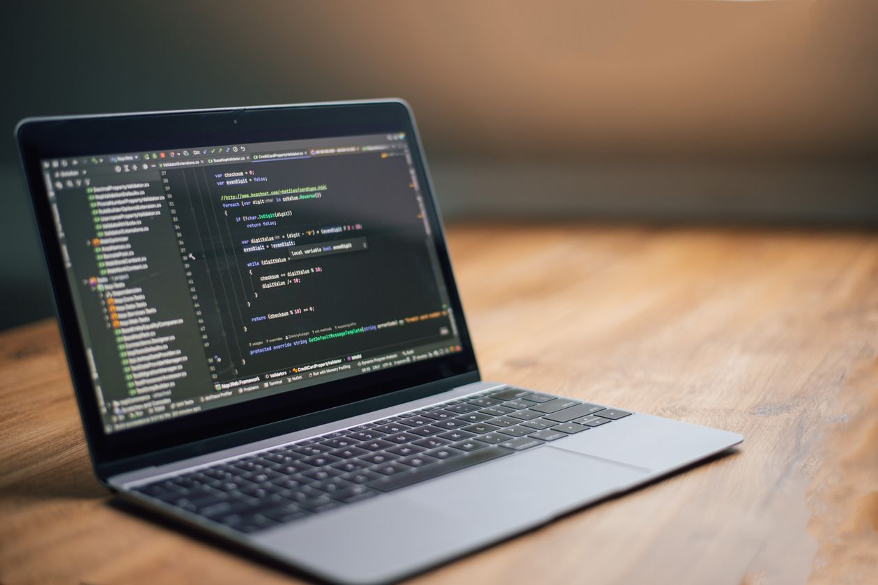 Laptop displaying code on a wooden table