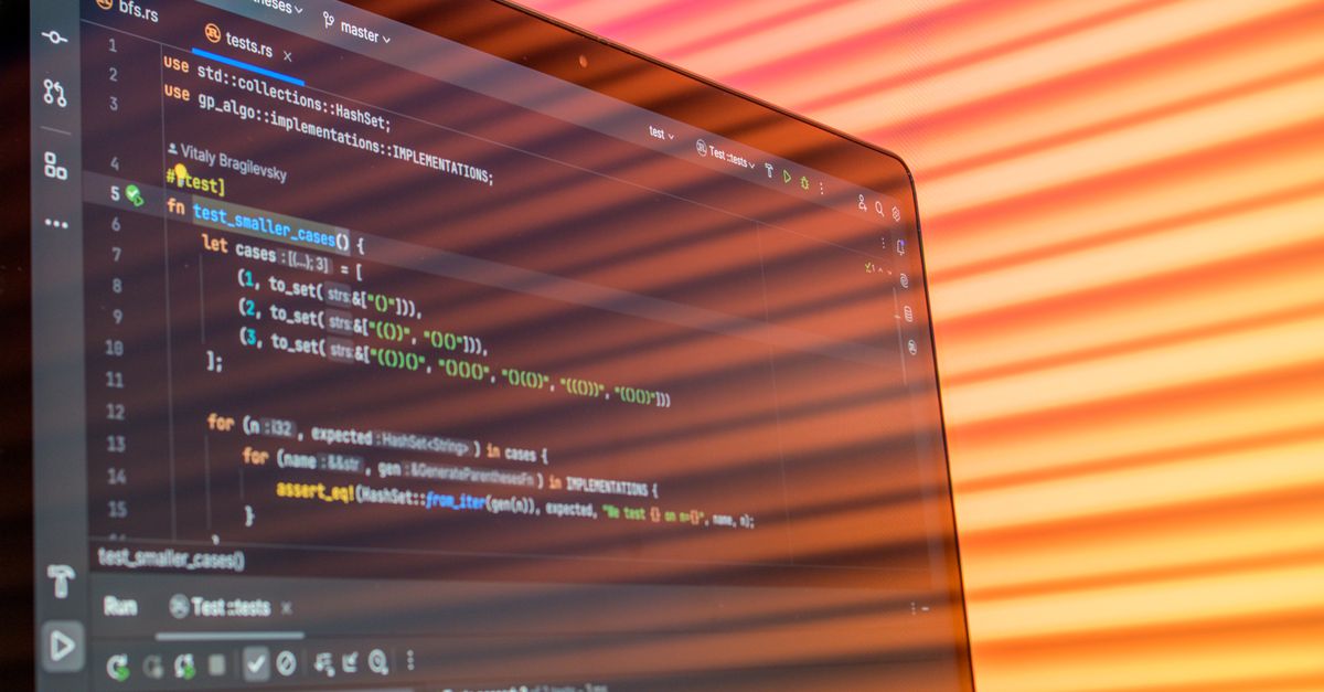 Colorful abstract reflection on screen showing programming code in development environment.