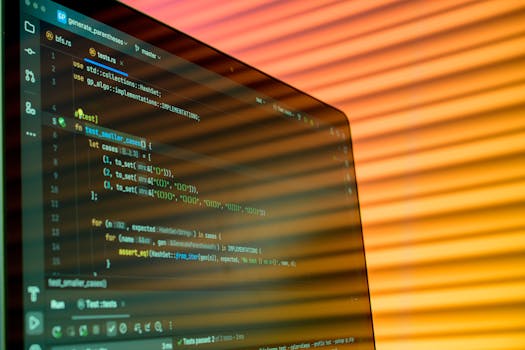 Blurry close-up of a computer screen displaying code with orange lighting.