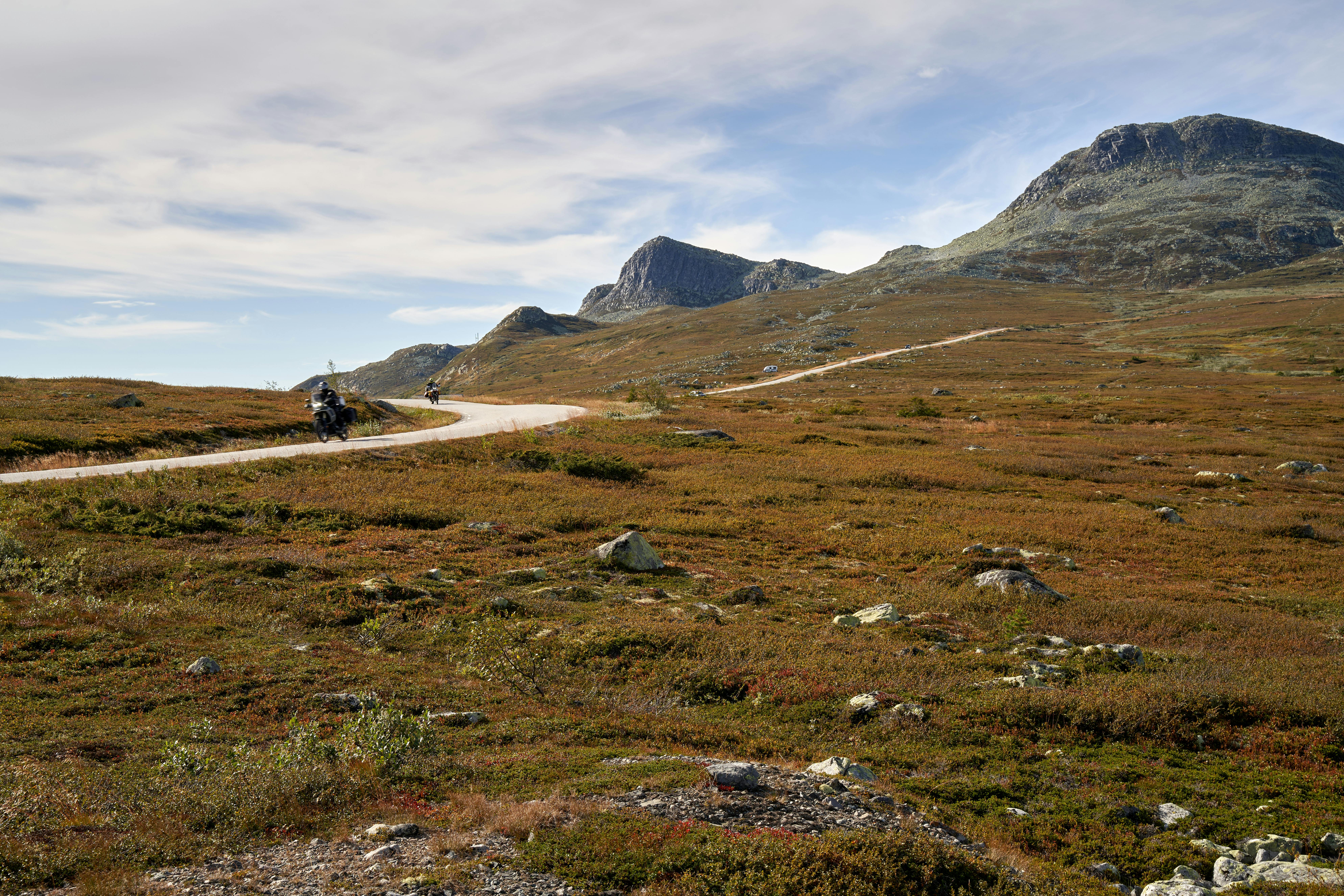 Two motorcyclists enjoy a scenic ride in Gaustatoppen, Telemark, Norway's stunning landscape.
