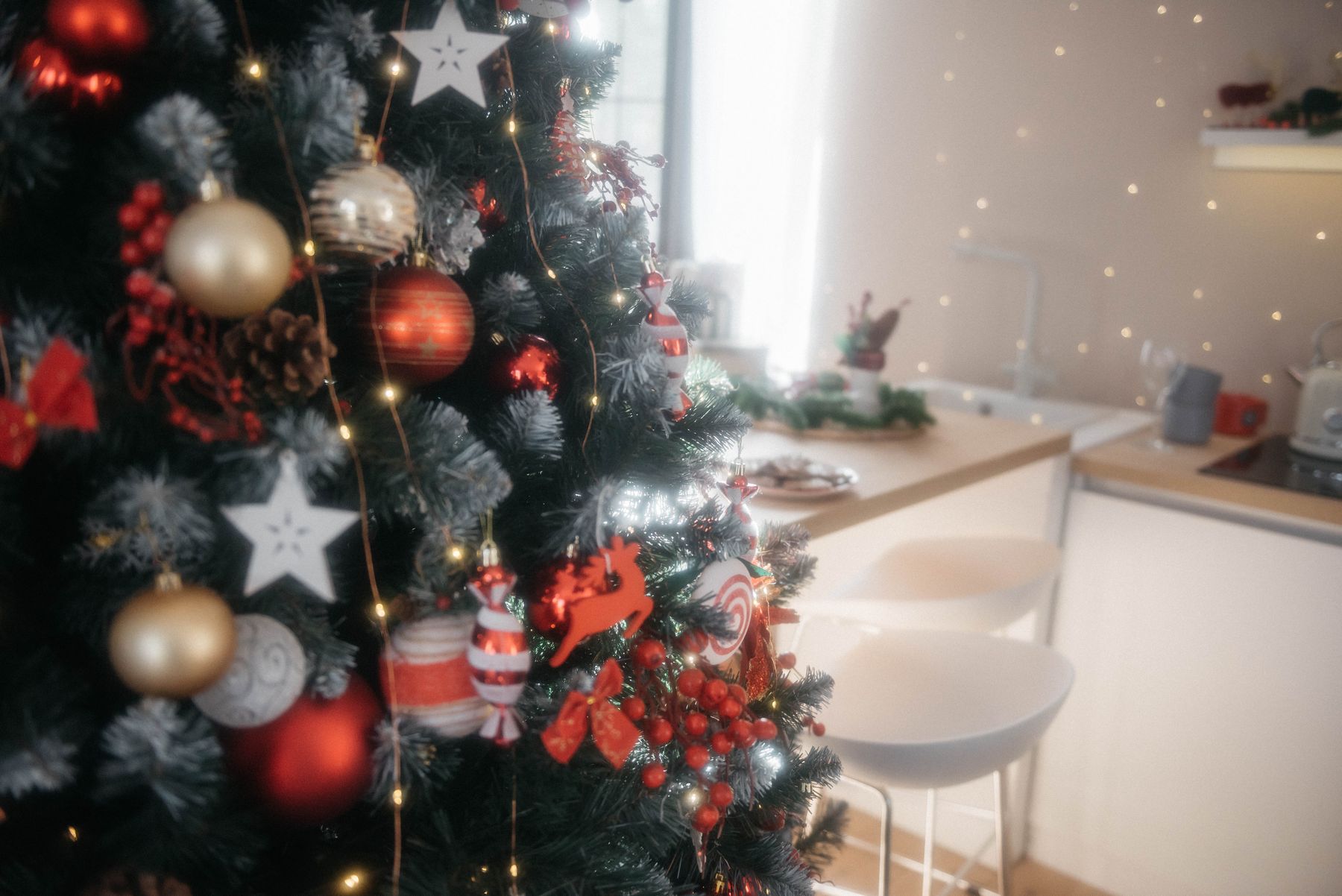 Decorated Christmas tree positioned in a cozy kitchen