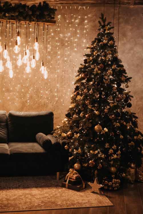 warm-christmas-lighting Warm Christmas fairy lights and hanging bulbs glowing beside a decorated tree
