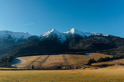 Breathtaking panoramic view of the snow-capped mountains and open fields in Ždiar, Slovakia.