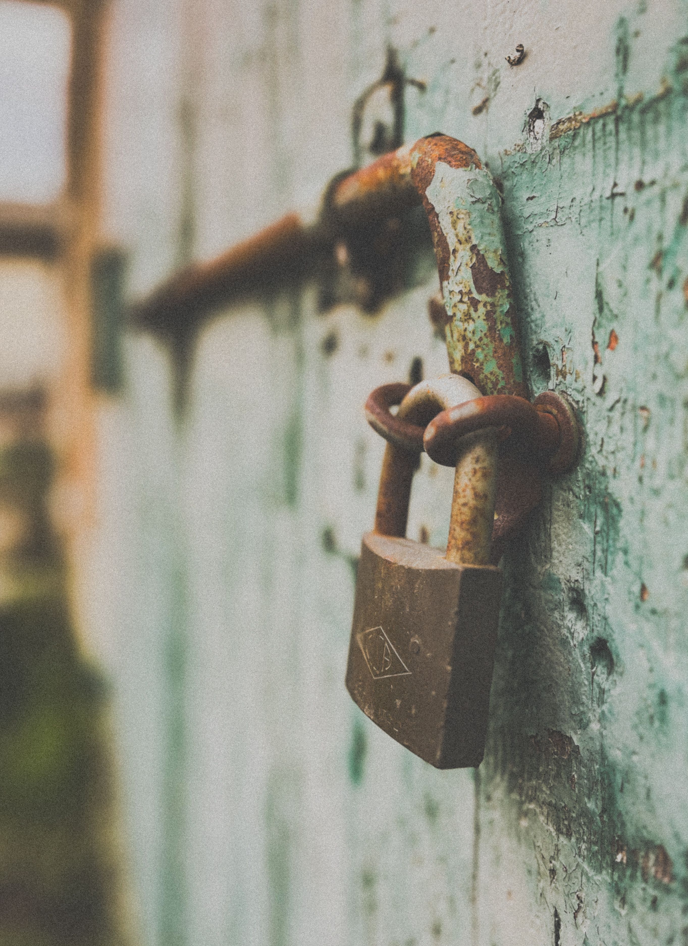 Free Close-up of a rusty padlock on an old wooden door, symbolizing security. Stock Photo